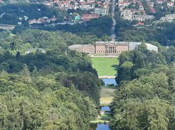 Blick vom Herkules über den Bergpark auf Schloss Wilhelmshöhe und die Wilhelmshöher Allee, die schnurgerade in die Stadt Kassel führt.