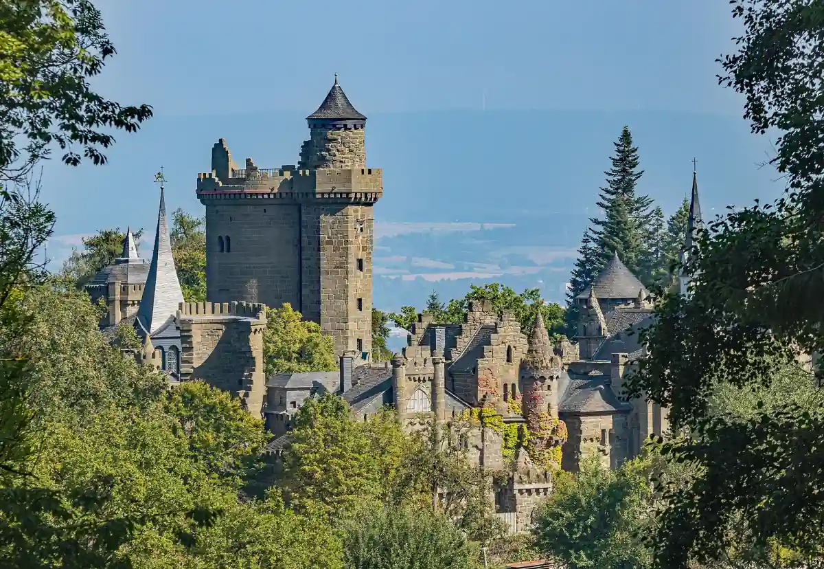 Die Türme der Löwenburg ragen aus den Bäumen des Bergparks Wilhelmshöhe.