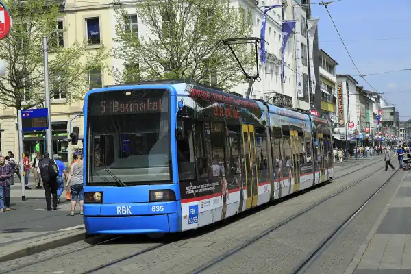 Eine blaue Kasseler Straßenbahn hält an der Haltestelle Friedrichsplatz in der Innenstadt.
